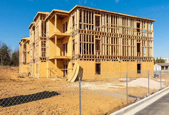 a temporary chain link fence in front of a building under construction, ensuring public safety in Copiague